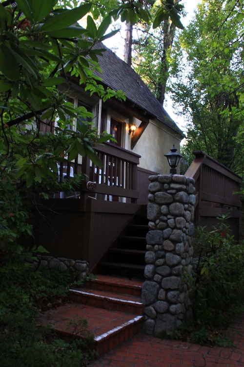 A house with stairs and a stone pillar.